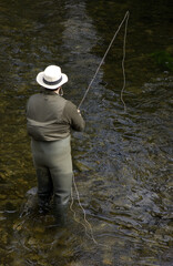 river fisherman, seen from behind with his rod