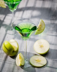 Appletini cocktail, apple martini cocktail garnished with green apple. Martini alcoholic cocktail or non-alcoholic mocktail. Martinis.