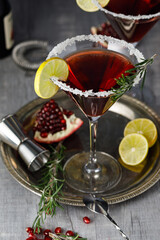 Pomegranate martini cocktail garnished with lemon and rosmarine. Martini alcoholic cocktail or non-alcoholic mocktail. Martinis.