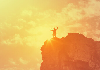 silhouette of a man flexing on a mountain top. Never give upheaving courage and strength concept 
