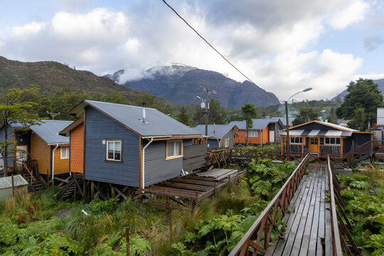 Small colorful houses and nalca plants along the wooden paths of Tortel, Patagonia, Chile
