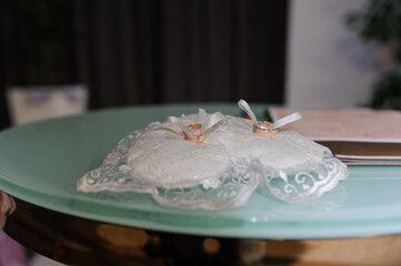 Golden wedding rings on a stand on the table. wedding ceremony