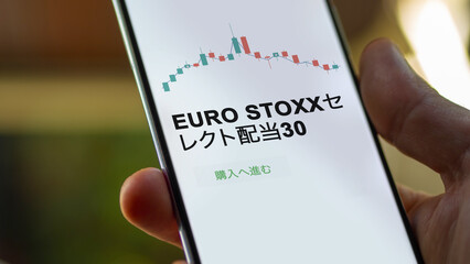 Investor analyzing an ETF. Funds stocks exchange ETFs Japanese text: euro stoxx select dividend 30, buy. EURO STOXXセレクト配当30 証券取引所 投資 shares