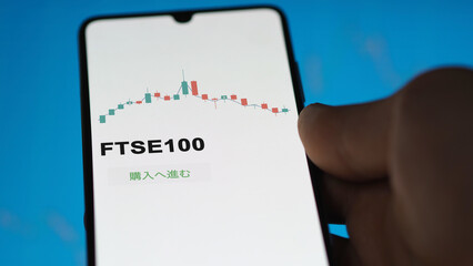 Investor analyzing an ETF. Funds stocks exchange ETFs Japanese text: ftse100, buy. FTSE100 証券取引所 投資 shares