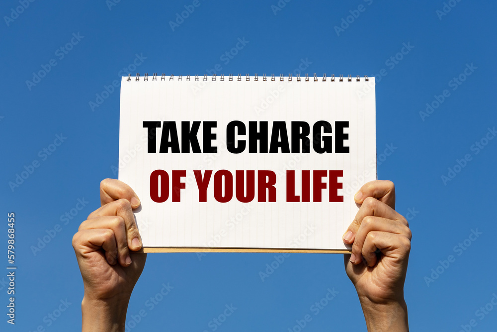 Poster take charge of your life text on notebook paper held by 2 hands with isolated blue sky background. t