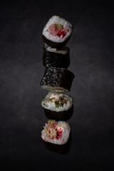 sushi set vertically floats in the air on a dark soft background. traditional japanese food