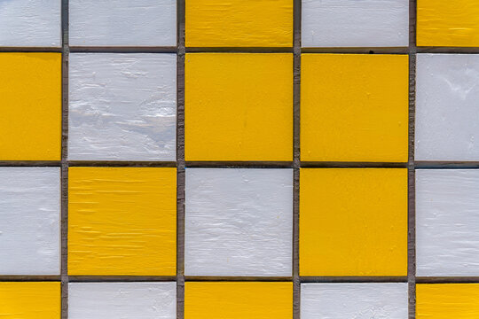 Grids with painted yellow and white on a food stand at the beach in Miami, Florida. Close-up of a structure with abstract yellow and white pattern.