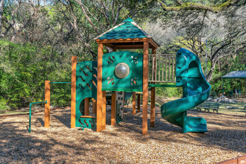 Austin, Texas- Playhouse with spiral slides in a community park. Forest park with playground...
