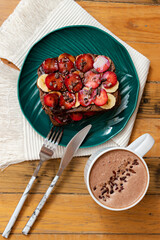 Overhead Shot Of A Plate With Sliced Bread With Fruit Toppings And A Cup Of Sparkling Chocolate On The Side