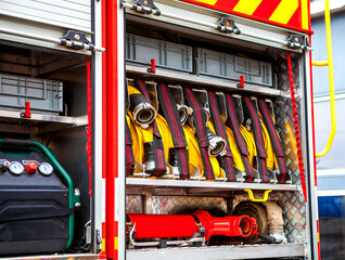 Compartment of rolled up fire hoses on a fire engine. Rescue fire truck equipment.