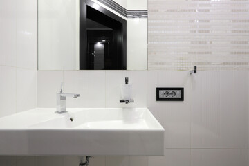 Fototapeta na wymiar Faucet with ceramic sink and mirror in the bathroom