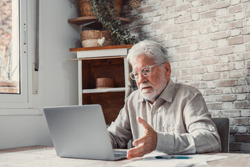 Annoyed worried aged man pensioner sit by laptop unable to make utility bill loan payment online...