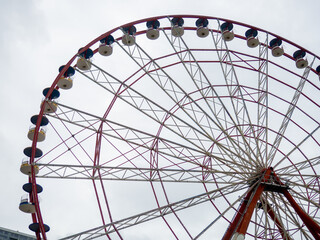 Ferris wheel on a cloudy day. Cloudy sky. Ferris wheel in an amusement park. W