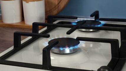 Fototapeta na wymiar White gas cooktop with turned on burners in kitchen