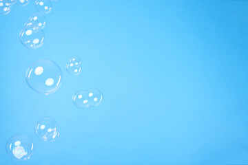 Many beautiful soap bubbles on light blue background. Space for text