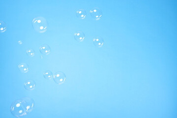 Many beautiful soap bubbles on light blue background. Space for text