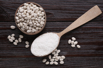 Fototapeta na wymiar Kidney bean flour and seeds on wooden table, flat lay
