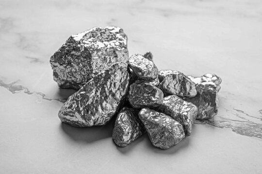 Pile of silver nuggets on white marble table, closeup