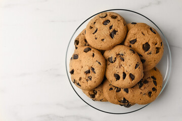 Delicious chocolate chip cookies on white marble table, top view. Space for text