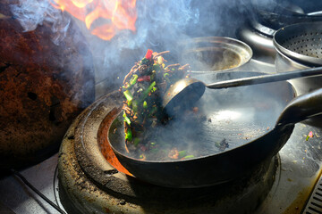 A chef in Xinjiang is frying a delicacy quickly, the flames are flying and the aroma is overflowing