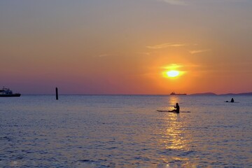 Naklejka na ściany i meble Tourists fishing on Koh Larn beach in Pattaya at sunset