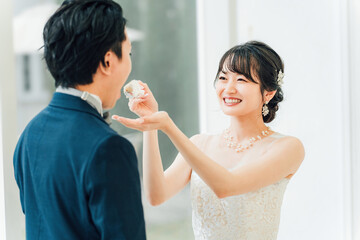 結婚式でファーストバイトをする新郎新婦(ウェディングケーキ・ケーキ入刀)
