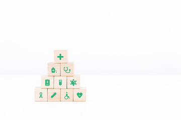 Wooden block stacking on white table and background. healthcare and medical science icon on wood cube arranged in a pyramid. copy space and isolated.