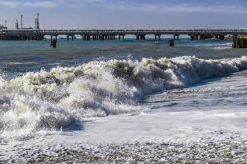 The power of water on the sea surf. Splashes of sea waves. Sea surf on the beach. Spray breaks from the waves, filling the air with a salty mist. Splashes of waves break on the rocks.