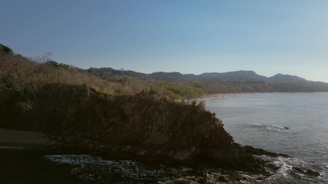 aerial reveal of Playa Conchal in Guanacaste region of Costa Rica, with people bathing and swimming in the water.