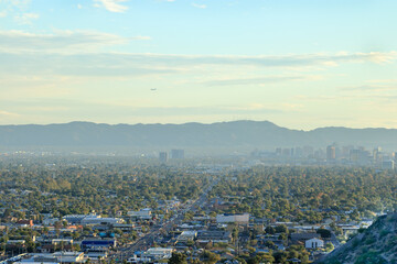 Evening  above distant downtown skyscrapers, buildings and residential houses between South and  North mountains known as Valley of The Sun, Phoenix, AZ