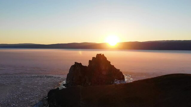Sunset over Lake Baikal in spring. Shamanka Rock or Cape Burkhan on Olkhon Island.