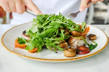 A plate of chorizo, caramelised onions and mushrooms, fresh arugula (baby rocket) on toasted sourdough at a cafe in Cairns City — Far North Queensland, Australia