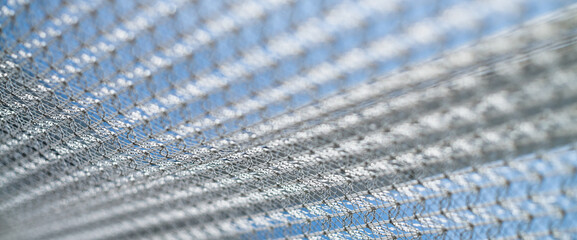 Beautiful white tulle on window on blurry background of blue sunny sky close up. White clear...