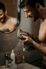 Shot of a young man holding a towel after washing his face in a bathroom at home.