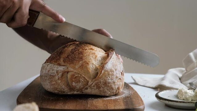 Artisan Batard Sourdough healthy Bread with leaf scoring. Open crumb high hydration Sourdough bread set on white table.