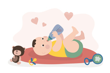 Newborn baby lies on carpet and drinks milk from bottle. Little baby eats from a bottle. Healthy food for baby growth. Adorable infant. Childhood, happy child with toys.
