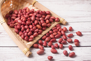 red peeled peanuts on wooden table.