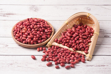 red peeled peanuts on wooden table.