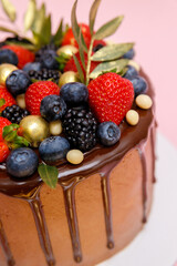 Chocolate cake in chocolate glaze with strawberries, blueberries and blackberries. Cooking and dessert recipes