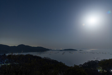 Fototapeta na wymiar 日本の岡山県備前市の頭島の海に浮かぶ月