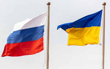 Flags of Russia and Ukraine against the sky.