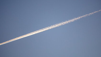 Airplane trail against the blue sky.