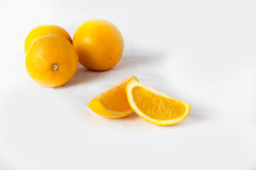 Sliced orange with oranges in the background