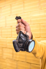 Man holding a gas mask on yellow background