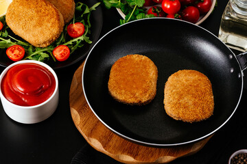 chicken cutlet. vegetables and herbs are lying side by side on t