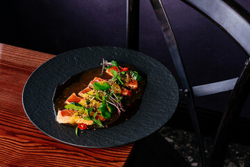 salmon carpaccio with sauce and herbs