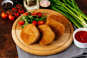 chicken cutlet on a wooden board. vegetables and herbs