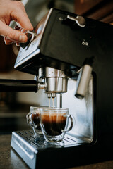 Young man making espresson for a latte