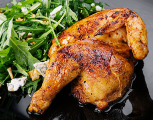 fried chicken with arugula salad on black plate