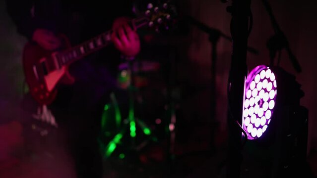 Man is playing guitar on stage.close up,Animation multicolor lights